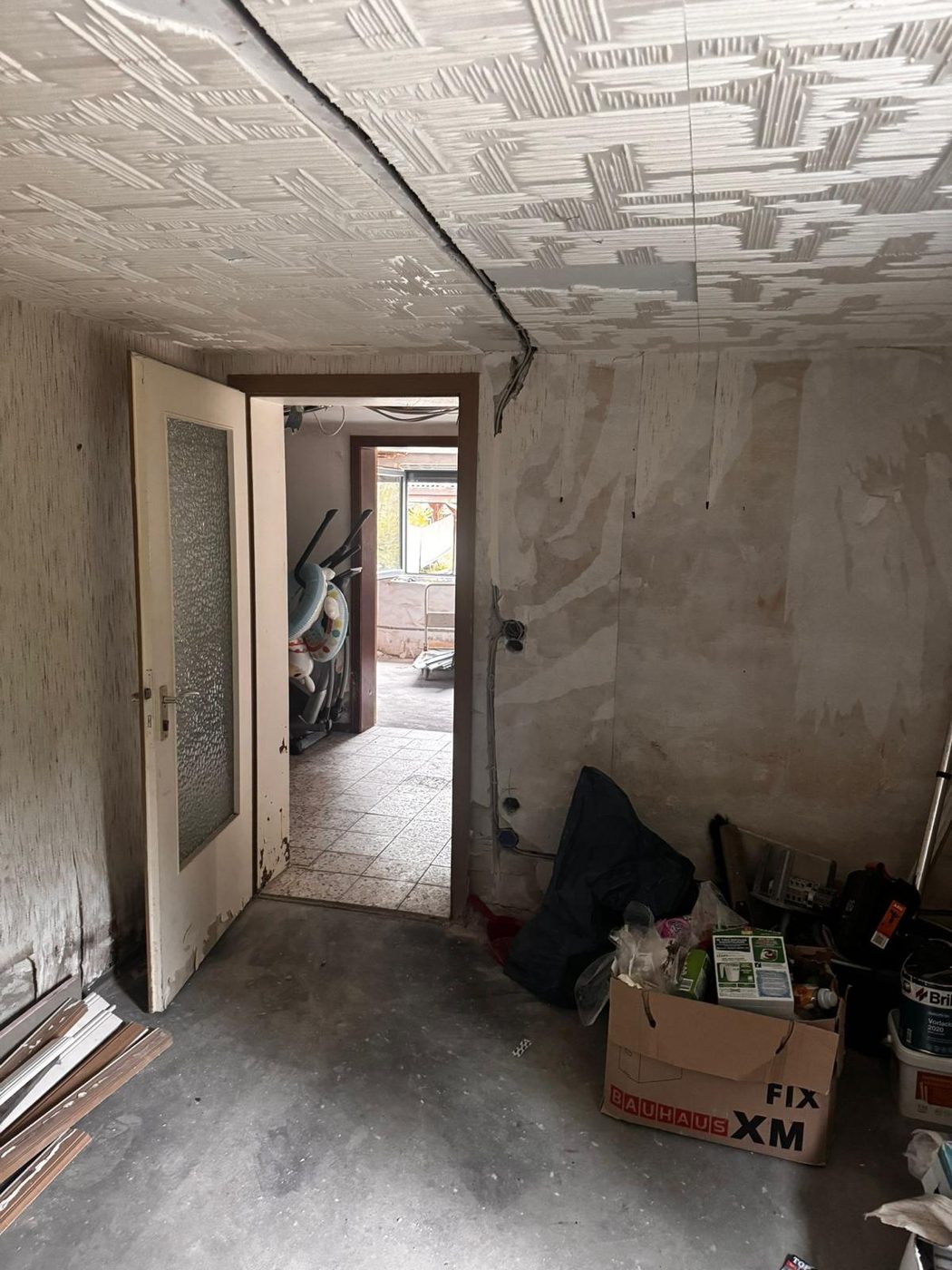 Flur im Altbau vor der Renovierung mit alter Styropordecke und abgelöster Tapete