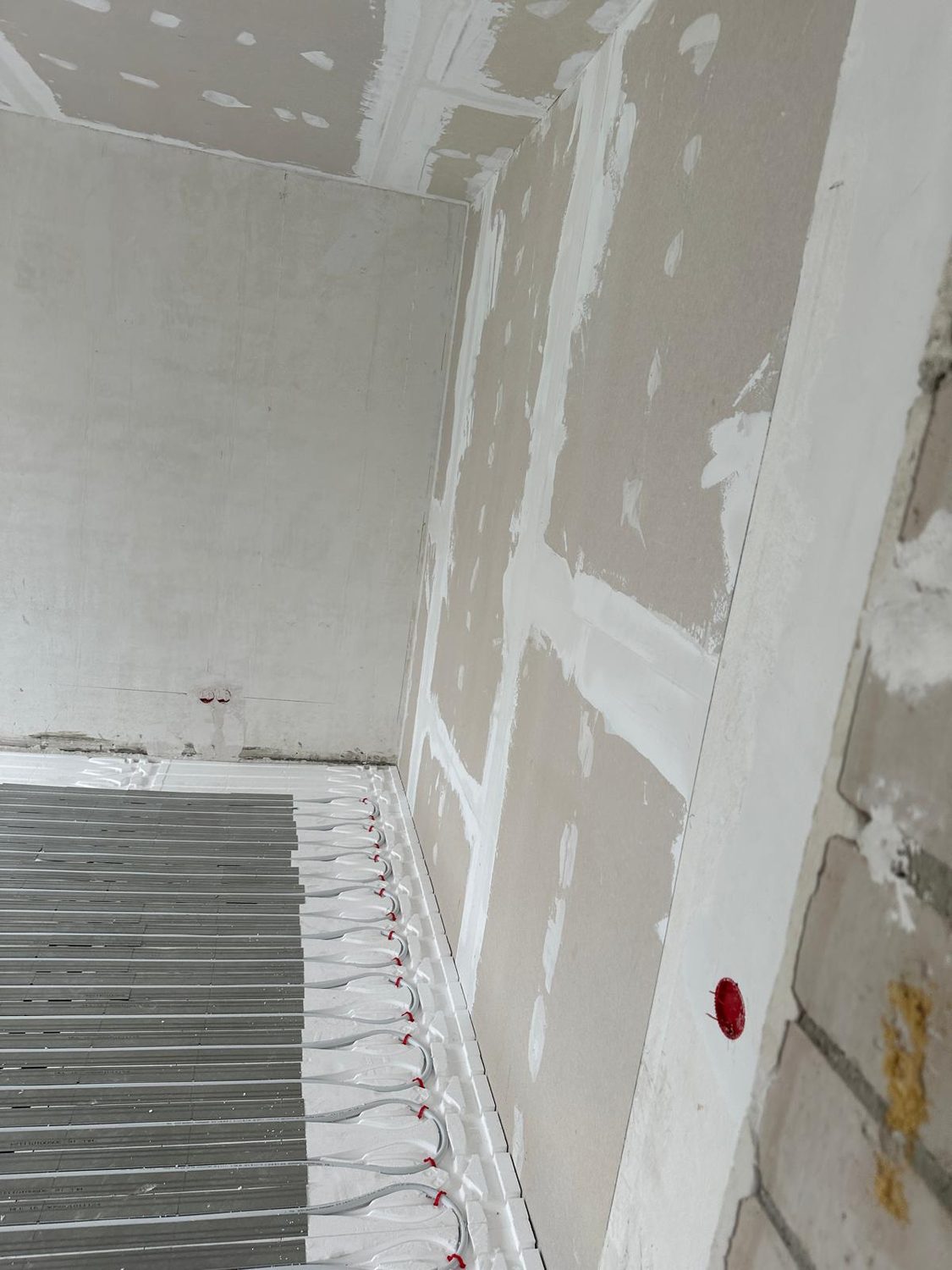 Frisch gespachtelte Trockenbauwand über verlegter Fußbodenheizung